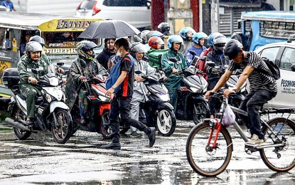 <p><strong>HERE COMES THE RAIN.</strong> Pedestrians and two-wheel riders deal with a sudden downpour at the intersection of Kamuning and Kamias Roads along EDSA, Quezon City on May 29, 2024. The weather bureau declared the start of the wet season late last month after significant rainfall over the western sections of Luzon and the Visayas, frequent thunderstorms, and Typhoon Aghon.<em> (PNA photo by Joan Bondoc)</em></p>