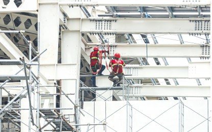 <p><strong>WAGE HIKE. </strong>Two workers work on steel bridges of the Metro Rail Transit - 7 in Commonwealth Avenue, Quezon City in this June 7, 2024 photo. Labor group Unity for Wage Increase Now (UWIN) on Wednesday (July 10, 2024) asked the NCR wage board to reconsider its bid of a PHP597 wage increase, to make the daily minimum wage rate in the region to PHP1,207. <em>(PNA file photo by Robert Oswald P. Alfiler) </em></p>