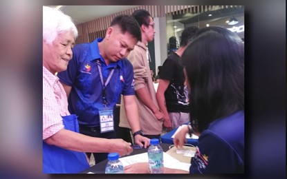<p><strong>NO AGE LIMIT</strong>. Evelyn Cotaran, 77, is assisted by a Department of Labor and Employment-Cordillera personnel in registering as an applicant for the Kalayaan (Independence) Day Job Fair in Baguio City on Wednesday (June 12, 2024). More than 1,500 vacancies were offered by private companies and government agencies during the event. <em>(PNA photo by Liza T. Agoot)</em></p>