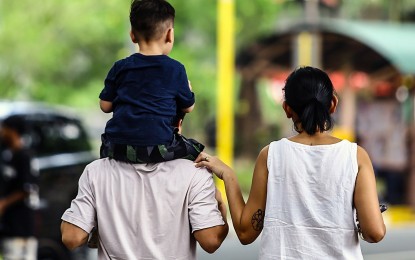 <p><strong>FAMILY WEEK</strong>. A couple and their son walk around a park in Quezon City on June 15, 2024. Malacañang has issued Memorandum Circular 64, shortening the work hours in government offices on Sept. 23 in line with the observance of the 32nd National Family Week and Kainang Pamilya Mahalaga Day. <em>(PNA photo by Joan Bondoc)</em></p>