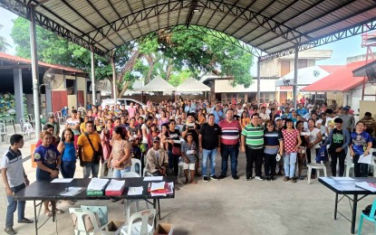 <p><strong>AID DISTRIBUTION.</strong> Negros Oriental Governor Manuel Sagarbarria (front row, in red shirt) leads the distribution of financial assistance to hog farmers affected by the African swine fever in Amlan town in this undated photo. Some 4,000 swine farmers have already received financial assistance amounting to some PHP22 million. <em>(Photo courtesy of Provincial Veterinary Office-Negros Oriental)</em></p>