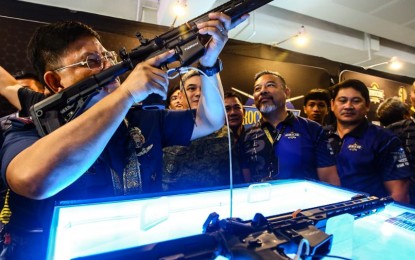 <p><strong>ACCESSIBLE GUN PERMITS.</strong> PNP chief Gen. Rommel Francisco Marbil (left) checks one of the weapons displayed at the Tactical, Survival and Arms Expo in Mandaluyong City on Thursday (June 20, 2024). Marbil said he has ordered the creation of gun permit renewal centers in the Visayas and Mindanao.<em> (PNA photo by Joan Bondoc)</em></p>