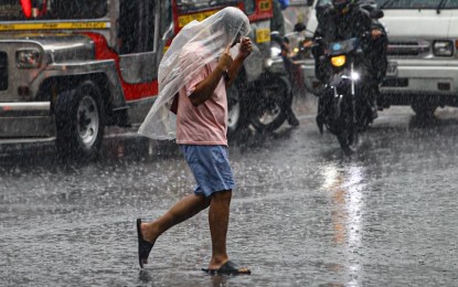 <p><strong>SOAKED.</strong> A man soaked in pouring rain in this undated photo. The low-pressure area last spotted 135 km. west-southwest of Calapan City, Oriental Mindoro, and the southwest monsoon will continue to bring rain showers across the country Friday (July 19, 2024), the weather bureau said. <em>(PNA photo by Joan Bondoc)</em></p>