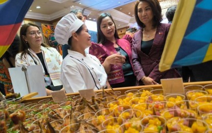 <p><strong>FOOD TOURISM.</strong> Secretary Christina Frasco (right) and DOT Caraga Region Director Dumadag (2nd from right) visit the Caraga Region's booth during the UN Tourism Gastronomy Forum's Regional Cocktail Lunch at Shangri-La Mactan on Wednesday (June 26, 2024). Frasco said the DOT is crafting a national gastronomy tourism roadmap that will position unique Filipino dishes in each of the Philippine regions as a main motivation for local and foreign tourists when choosing where to travel. <em>(PNA photo by Joan Bondoc)</em></p>