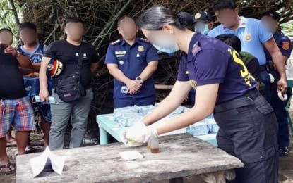 <p><strong>LATEST FIND</strong>. A personnel of the Ilocos Sur Provincial Police Forensic Unit examines the white crystalline substance in front of the public on Thursday (June 27, 2024). The samples, which yielded positive results for shabu, were taken from the black sack found by fishermen floating on the waters of the village of Villamar in Caoayan, Ilocos Sur on Wednesday morning but surrendered to the police later in the day. <em>(Photo courtesy of the Police Regional Office 1)</em></p>