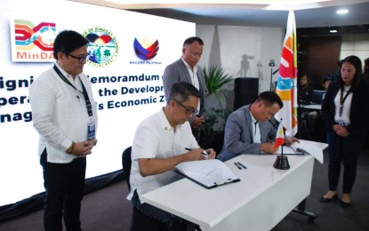 <p><strong>ECONOMIC DEVELOPMENT</strong>. Mindanao Development Authority (MinDA) Secretary Leo Tereso Magno (sitting left) and Dinagat Islands Governor Nilo Demerey Jr. (sitting right) sign a memorandum of cooperation (MoC) on Thursday (June 27, 2024) at the MinDA office in Davao City for the establishment of the economic zones in the province. The MoC aims to attract local and foreign investments, generate jobs, and reduce regional poverty. <em>(Photo courtesy of MinDA)</em></p>