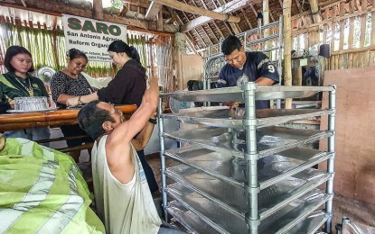 <p><strong>GOV’T AID.</strong> Members of the San Antonio Agrarian Reform Organization of Bombon town in Camarines Sur assemble the Portable Solar Dryer-Grains Thermal Drying Trays (Portasol-GTDTs) they received from the Department of Science and Technology on June 26, 2024. Portasols serve as an alternative to traditional sun-drying methods, maintaining quality while protecting rice and other food products from contamination. <em>(Photo courtesy of DAR-Camarines Sur ll)</em></p>