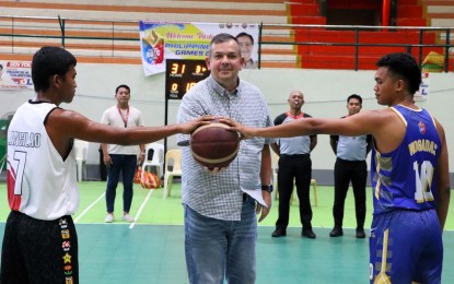 <p><strong>ROTC GAMES.</strong> Philippine Sports Commission (PSC) Chairman Richard Bachmann (center) prepares to make the ceremonial toss during the Philippine Reserve Officers Training Corps (ROTC) Games men's basketball tournament at the Universidad de Zamboanga Summit Center in Tetuan, Zamboanga City on Wednesday (June 26, 2024). He also watched other sports. <em>(Photo courtesy of PSC) </em></p>