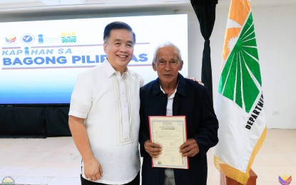 <p><strong>NEW LAND OWNER</strong>. Department of Agrarian Reform-Bicol (DAR-5) Regional Director Reuben Theodore Sindac (left), in a photo opportunity with Cresenciano Colagong, holding his new land title during the Kapihan sa Bagong Pilipinas in Legazpi City on June 25, 2024. Colagong was among the beneficiaries when President Ferdinand R. Marcos Jr. distributed land titles during his visit to Camarines Sur on June 7, 2024. <em>(Photo courtesy of DAR Bicol)</em></p>