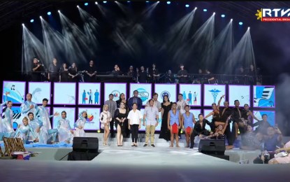 <p><strong>MUSIC AT THE PALACE. </strong>President Ferdinand R. Marcos Jr. (4th from left) and First Lady Liza Araneta-Marcos (in white) join Filipino music icon Martin Nievera (behind the President) and other local artists who performed in the "Konsyerto sa Palasyo: Para sa ating mga Healthcare Workers" (Concert at the Palace: For our Healthcare Workers) at the Kalayaan Grounds of Malacañang Palace, Manila on Sunday night (June 30, 2024). The 4th Konsyerto sa Palasyo was organized to pay tribute to the sacrifices of Filipino healthcare workers, especially at the height of the Covid-19 pandemic. <em>(RTVM screengrab)</em></p>