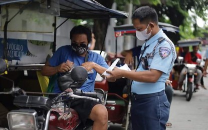 <p><strong>'NO PLATE, NO TRAVEL'.</strong> A traffic enforcer inspects the documents of a tricycle driver in Quezon City on Monday (July 1, 2024), the first day of implementation of the "no plate, no travel" policy. At least 23 tricycle drivers were apprehended in the colorum crackdown.<em> (LTO photo)</em></p>