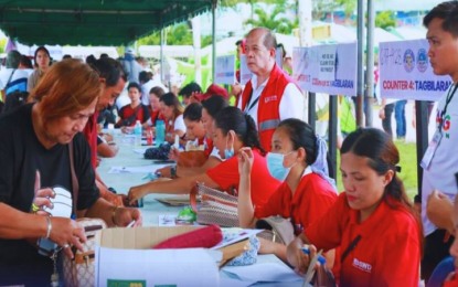 <p><strong>CASH AID DISTRIBUTION</strong>. The Department of Social Welfare and Development (DSWD) personnel distribute cash assistance to the victims of the El Niño phenomenon in this undated photo. The DSWD on Tuesday (July 2, 2024) said it has distributed more than PHP1.37 billion in cash aid the affected farmers, fisherfolk and their families. <em>(Photo courtesy of DSWD)</em></p>