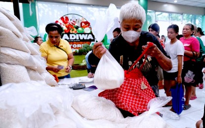 <p><strong>CONTINUOUS ROLLOUT</strong>. A senior citizen bags 10 kilos of rice that cost PHP29 per kilogram she bought at the Department of Agriculture-Agribusiness Development Center Kadiwa Store in Elliptical Road, Diliman, Quezon City on July 8, 2024. The Department of Agriculture on Wednesday (Oct. 2) vowed to continue its rollout alongside the Rice for All program to benefit more Filipinos with affordable and good quality rice. <em>(PNA file photo by Ben Briones)</em></p>