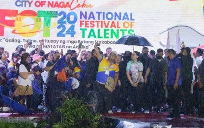 <p><strong>NATIONAL EDUCATION EVENTS</strong>. Vice President and Education Secretary Sara Duterte (shielded by umbrella) joins the crowd on stage during the opening ceremony of the National Festival of Talents in Naga, Cebu on Monday (July 8, 2024). The festival is one of the six major national events of the Department of Education to simultaneously open in Cebu until July 17. <em>(Photo courtesy of DepEd)</em></p>