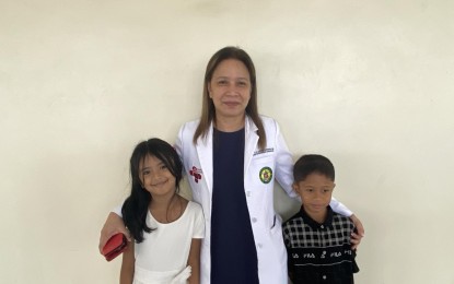 <p><strong>HEART CARE</strong>. Dr. Eloisa Claveria-Barrion, the only pediatric interventional cardiologist in the region and head of Bicol Medical Center's Cardiac Center together with two of her 23 patients, in this photo taken on July 2, 2024. With the establishment of the BMC Cardiac Center, Bicolanos no longer need to travel to Metro Manila for their cardiovascular treatment. <em>(PNA photo by Connie Calipay)</em></p>