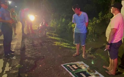 <p><strong>ARRESTED.</strong> Drug suspect Ryan Espiritu Sunga (in blue t-shirt) of General Santos City watches as police officers account for the PHP1.2 million worth of shabu drugs seized from him during an entrapment operation in Kidapawan City on Tuesday night (July 9, 2024). The suspect allegedly transacted to sell the illegal drugs to a police poseur-buyer. <em>(Photo courtesy of Kidapawan CPO)</em></p>