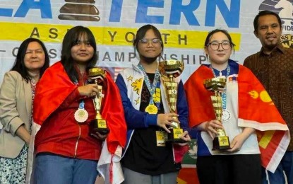 <p><strong>VICTORIOUS.</strong> The Philippines’ Bonjoure Fille Suyamin (center) holds the champion's trophy during the awarding ceremony of the 8th Eastern Asian Youth chess tournament in Penang, Malaysia on Saturday (July 13, 2024). She tallied six points to rule the girls’ U-16 rapid event. <em>(Contributed photo)</em></p>