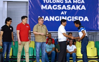 <p><strong>CASH AID.</strong> President Ferdinand R. Marcos Jr. shakes hands with a beneficiary during the delivery of assistance for farmers, fishers and families affected by El Niño in Cavite and Rizal provinces in a ceremony held in Dasmariñas City, Cavite on July 11, 2024. Marcos enjoyed high trust and performance scores ahead of his third State of the Nation Address, based on the independent, non-commissioned survey by RP-Mission and Development Foundation Inc. <em>(PNA photo by Joan Bondoc)</em></p>