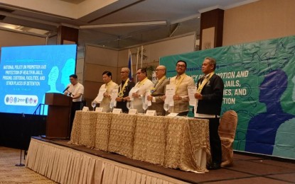 <p><strong>IMPROVING PDLs' HEALTH.</strong> Officials of the Department of Justice, Department of Health and other concerned agencies show a copy of the "National Policy on Promotion and Protection of Health in Jails, Prisons, Custodial Facilities, and Other Places of Detention" at the Manila Hotel on Monday (July 15, 2024). The Bureau of Corrections said the policy would guarantee a strong collaboration among concerned agencies on improving PDLs' health through their automatic inclusion in the National Health Insurance Program.<em> (Photo courtesy of BuCor)</em></p>