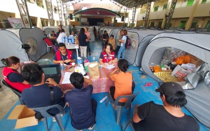 <p><strong>VALIDATION.</strong> Personnel of the City Social Welfare and Development Office (CSWDO) conduct validation on Monday (July 15, 2024) at the Magallanes Central Elementary School, where the victims of the July 13 fire in Barangay 2-A, Davao City, are temporarily staying. The CSWDO interviewed the affected families to determine the assistance they need.<em> (PNA photo by Robinson Niñal Jr.)</em></p>