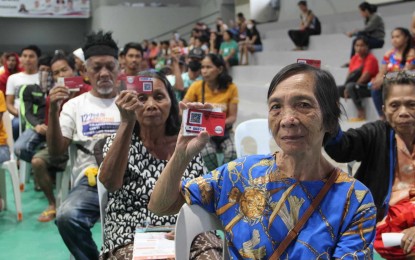 <p><strong>FIGHTING HUNGER</strong>. Recipients hold their electronic benefit transfer (EBT) cards during a ceremonial redemption in Palo, Leyte on Thursday (July 18, 2024). Under the program, each family gets PHP3,000 per month on their EBT card for three years to buy nutritious food. <em>(Photo courtesy of Department of Social Welfare and Development)</em></p>