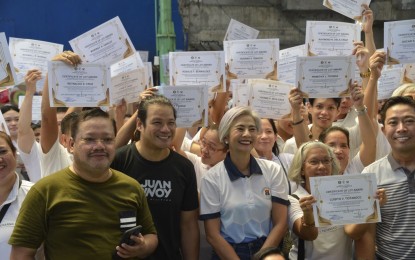 <p><strong>DREAM COME TRUE.</strong> Officials of the city government of Manila led by Mayor Honey Lacuna (center) pose with the recipients of lot certificates in Tondo, Manila on Friday (July 19, 2024). A total of 133 residents from Barangay 210 and Barangay 152 in Tondo received certificates of lot award. <em>(Photo courtesy of Dr. Honey Lacuna Facebook)</em></p>