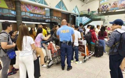 <p><strong>CONGESTION.</strong> A police officer helps manage the queue at Davao International Airport in Davao City on Friday (July 19, 2024). The global Microsoft system outage has affected airline operations, resulting in delays and flight cancellations. <em>(Photo courtesy of CAAP Facebook)</em></p>