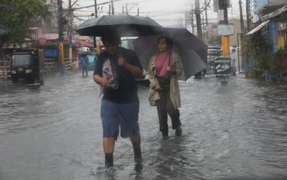 <p><strong>MEGA MANILA FLOODS.</strong> Commuters wade through floodwater in Bacoor, Cavite on July 23, 2024. Meralco said over 124,000 customers in its franchise area were affected by power outage as of 12 noon of Wednesday (July 24, 2024) due to Typhoon Carina and the southwest monsoon. <em>(PNA photo by Avito Dalan)</em></p>