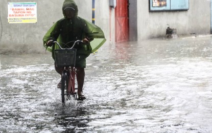 <p><strong>FLOOD.</strong> A man on his bike makes his way through a flooded street in this undated photo. Malacañang suspended government work and classes at all levels in Metro Manila on Wednesday (July 24, 2024), upon the recommendation of the National Disaster Risk Reduction and Management Council, due to the effects of the southwest monsoon (habagat), enhanced by Typhoon Carina. <em>(PNA photo by Joan Bondoc)</em></p>