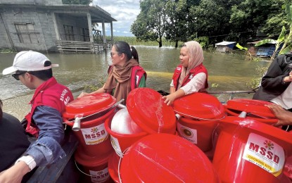 <p><strong>RELIEF.</strong> Personnel of the BARMM's Ministry of Social Services and Development deliver sets of non-food items for flood-affected families in Barangay Damatulan in the region's Special Geographic Area in this July 19, 2024 photo. The NDRRMC on Tuesday (July 23) said at least eight people died due to bad weather caused by the southwest monsoon and two tropical cyclones. <em>(Photo courtesy of BARMM Ministry of Social Services and Development)</em></p>