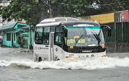 <p><strong>BUSINESS AS USUAL</strong>. A modern jeepney drives through an inundated portion of Quirino Highway in Novaliches, Quezon City on Wednesday (July 24, 2024). The labor department reminded employers about the rules on the suspension of work due to bad weather amid the heavy downpour in Metro Manila and other areas. <em>(PNA photo by Joan Bondoc)</em></p>