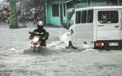 <p><strong>BRAVING THE FLOOD.</strong> A motorcycle rider and a light truck brave the flood along Quirino Highway in Novaliches, Quezon City on Wednesday (July 24, 2024). The DOLE on Thursday (July 25) said it is ready to help workers who were affected by massive floods caused by heavy rains from Typhoon Carina and the enhanced southwest monsoon.<em> (PNA photo by Joan Bondoc)</em></p>