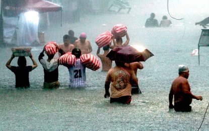 <p><strong>EVACUATION.</strong> Residents of Barangay Sto. Domingo in Florentino Street, Quezon City head for a designated evacuation center as heavy rains triggered waist-deep floods in the village on Wednesday (July 24, 2024). The Department of Education reported that 21 schools in Metro Manila and Calabarzon are being used as evacuation centers for families affected by the effects of Super Typhoon Carina and the enhanced southwest monsoon. <em>(PNA photo by Ben Briones)</em></p>