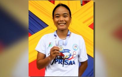 <p><strong>TRIPLE GOLD</strong>. Artjoy Torregosa of Central Visayas shows her gold medal after ruling the women's 3,000m run in the 2024 Private Schools Athletic Association (PRISAA) National Games at the Bicol University track and field stadium on Tuesday (July 23, 2024). Torregosa also won the 10,000m and 5,000m events. <em>(PNA photo by Jean Malanum)</em></p>