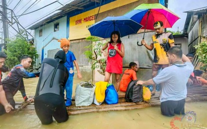 <p><strong>RESCUE</strong>. Government personnel help a family in San Fernando City, La Union evacuate following the rising flood waters in their area in this undated photo. The Department of Health placed all public health facilities under Code White alert status in response to possible emergencies. <em>(Photo courtesy of San Fernando City Facebook page)</em></p>