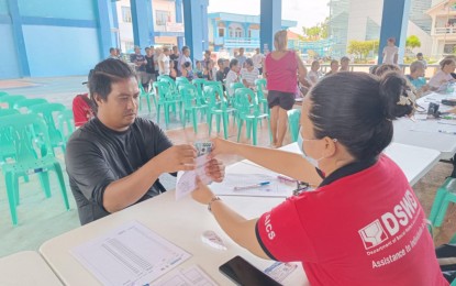 <p><strong>PAYOUT</strong>. Residents of Magallanes, Sorsogon whose houses were damaged by Super Typhoon Carina and the southwest monsoon receive cash assistance under the Department of Social Welfare and Development's Assistance to Individuals in Crisis Situation program on Monday (July 29, 2024). The DSWD-Bicol provided more than PHP3.4 million in assistance to the affected households.<em> (Photo courtesy of DSWD-Bicol)</em></p>