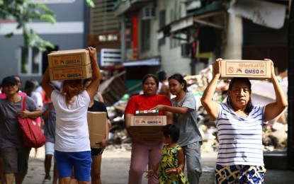 <p><strong>FOOD PACKS.</strong> Flood-affected residents carry home family food packs distributed by the Department of Social Welfare and Development (DSWD) in Barangay Masambong, Quezon City July 29, 2024. DSWD Secretary Rex Gatchalian on Monday (Aug. 19) warned that tampering or repacking of the agency’s family food packs (FFPs) is illegal and constitutes a criminal act following reports of repacking incidents that have been circulating in social media. <em>(PNA photo by Joan Bondoc)</em></p>