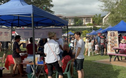 <p><strong>TOURIST INFLUX.</strong> Foreigners huddle around a food stall at the regular Sunday market in Valencia, Negros Oriental. Tourist arrivals in the province rose to over 350,000 for the first half of the year, the Provincial Tourism Office said Monday (July 29, 2024). <em>(PNA photo by Mary Judaline Flores Partlow)</em></p>