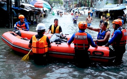 <p><strong>READY TO HELP.</strong> Quezon City Disaster Risk Reduction and Management Office (QCDRRMO) search and rescue personnel (in orange vests) and some volunteers prepare a motorized rubber boat for the evacuation of residents along Araneta Avenue, Quezon City on July 24, 2024. Department of National Defense (DND) Secretary Gilberto Teodoro Jr. said Thursday (Aug. 22) he would prefer measures to strengthen existing disaster response and mitigation agencies instead of creating a new one. <em>(PNA file photo by Ben Briones)</em></p>