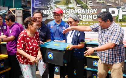 <p><strong>RELIEF OPS.</strong> Key officials of the Department of Human Settlements and Urban Development (DHSUD) and the Pag-IBIG Fund distribute relief packs to displaced families on Tuesday (July 30, 2024). Each relief pack contained a sleeping mat, a flashlight, three blankets, five plastic plates, five plastic drinking glasses, a cooking pot, and a pan. <em>(Photo courtesy of the DHSUD)</em></p>