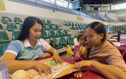 <p><strong>NUTRITION COUNSELING</strong>. A dietician explains to a mother the importance of proper diet using Pinggang Pinoy as a food guide. The Ilocos Norte government launched on Wednesday (July 31, 2024) a community outreach program to improve the nutrition status of children. <em>(PNA photo by Leilanie Adriano)</em></p>