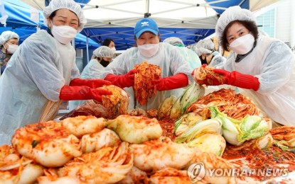 <p><strong>MOST WANTED.</strong> Volunteers pose with kimchi, a traditional Korean side dish normally made of fermented cabbage, salt and hot peppers, during an event held in eastern Seoul in this file photo. South Korea's outbound shipments of kimchi reached 23,900 tons during the first six months of 2024, up 4.8 percent from a year earlier<em>. (Yonhap)</em></p>