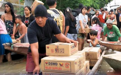 <p><strong>FOOD PACKS</strong>. Residents use boats to transport family food packs (FFPs) distributed by the Department of Social Welfare and Development (DSWD) to victims of massive flooding due to Typhoon Carina and the enhanced southwest monsoon in this undated photo. The DSWD said 1.26 million FFPs have been dispatched in a week.<em> (DSWD photo)</em></p>