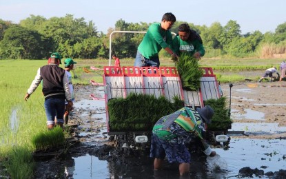 <p><strong>MODERN FARMING</strong>. Pangasinense farmers from Binalonan town use a transplanter from the Philippine Center for Postharvest Development and Mechanization (PhilMech) in this undated photo. PhilMech will donate another set of farm machinery and equipment to Pangasinan to support the latter's corporate farming program. <em>(Photo courtesy of DA-PhilMech)  </em></p>