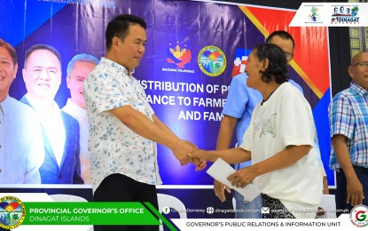 <p><strong>TIMELY INTERVENTION.</strong> Dinagat Islands Governor Nilo Demerey Jr. (left) leads the distribution of financial assistance to 316 farmers and fisherfolk in an activity conducted in Cagdianao town on Monday (Aug. 5, 2024). Some PHP3.1 million in aid through the Presidential Assistance to Farmers, Fisherfolk, and Families program was released during the event.<em> (Photo courtesy of Dinagat Governor’s Office)</em></p>