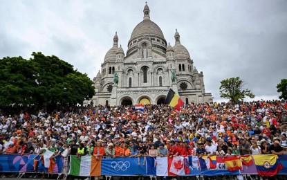 <p>Spectators watch the men's cycling road race at the Paris 2024 Olympic Games in Paris, France, Aug. 3, 2024. <em>(Xinhua/Hu Huhu)</em></p>