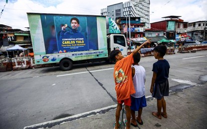 <div class="caption my-4">
<p><strong>NATIONAL TREASURE</strong>. An open truck with an electronic billboard of Paris Olympics double gold medalist Carlos Yulo traverses NIA Road, Quezon City on Tuesday (Aug. 6, 2024). The 24-year-old gymnast is scheduled to arrive home on Aug. 13, with a motorcade taking him and the other Olympians to Malacañan Palace in Manila for an audience with President Ferdinand R. Marcos Jr. <em>(PNA photo by Joan Bondoc)</em></p>
</div>