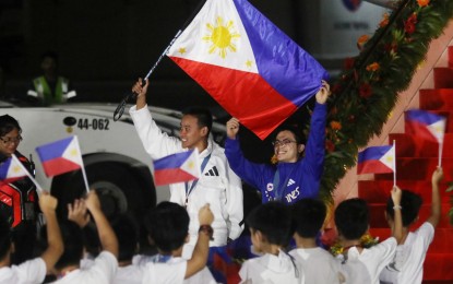 <p><strong>HEROES’ WELCOME</strong>. Olympic gold medalist Carlos Yulo (in blue) and bronze medalist Nesthy Petecio walk down the runway of Villamor Air Base in Pasay City on Tuesday night (Aug. 13, 2024). The welcome ceremonies culminated at Malacañang Palace in Manila where President Ferdinand R. Marcos Jr. awarded their cash incentives. <em>(PNA photo by Avito C. Dalan)</em></p>