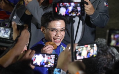 <p><strong>TAX FREE</strong>. Paris Olympics double-gold medalist Carlos Yulo shows his medal to the fans during the Filipino Olympians’ welcome parade in Manila on Aug. 14, 2024. Bureau of Internal Revenue Commissioner Romeo Lumagui Jr. on Monday (Aug. 26) said Paris Olympics double-gold medalist Carlos Yulo does not have to pay taxes for the prizes, awards, rewards, gifts, and donations he received by his historic performance. <em>(PNA photo by Avito C. Dalan)</em></p>