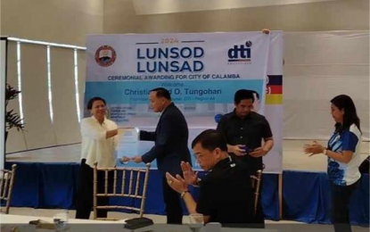 <p><strong>REWARDING INNOVATION.</strong> Department of Trade and Industry (DTI) Calabarzon Assistant Regional Director Revelyn Cortez hands over to Mayor Roseller Rizal the certificate acknowledging Calamba City as 2024 Lunsod Lunsad Awardee on Aug. 13, 2024 at the Function Hall of Rizal Coliseum in Calamba City. Cortez said on Wednesday (Aug 14, 2024) that the Lunsod Lunsad Award is the agency’s way of boosting competitiveness and creativity among cities across the country. <em>(Photo by Zen Trinidad)</em></p>